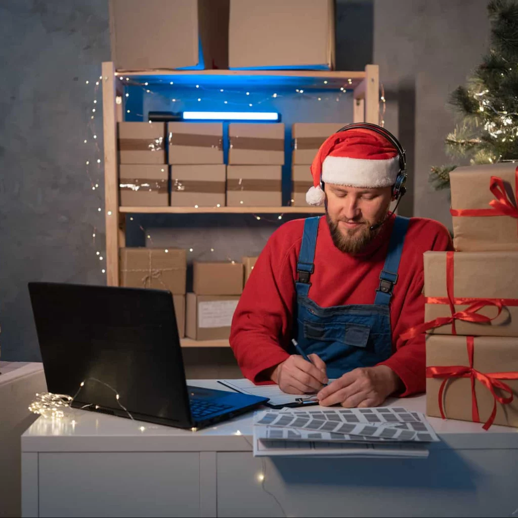 Small business, aspiring entrepreneur working late into the night, santa hat, holiday returns